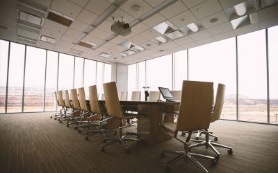 Empty corporate boardroom with a long table and windows
